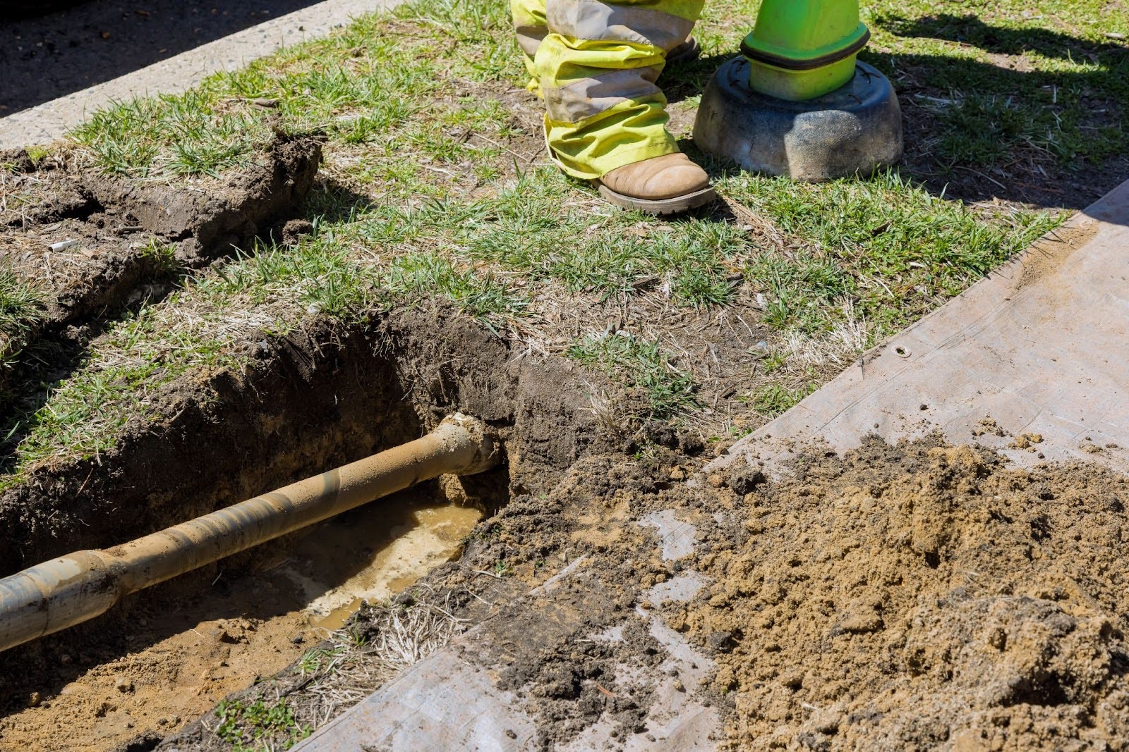 Technician next to an open sewer line.