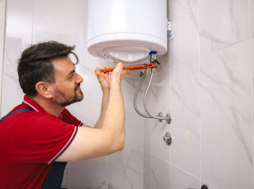 A plumber repairing a bathroom water heater unit.