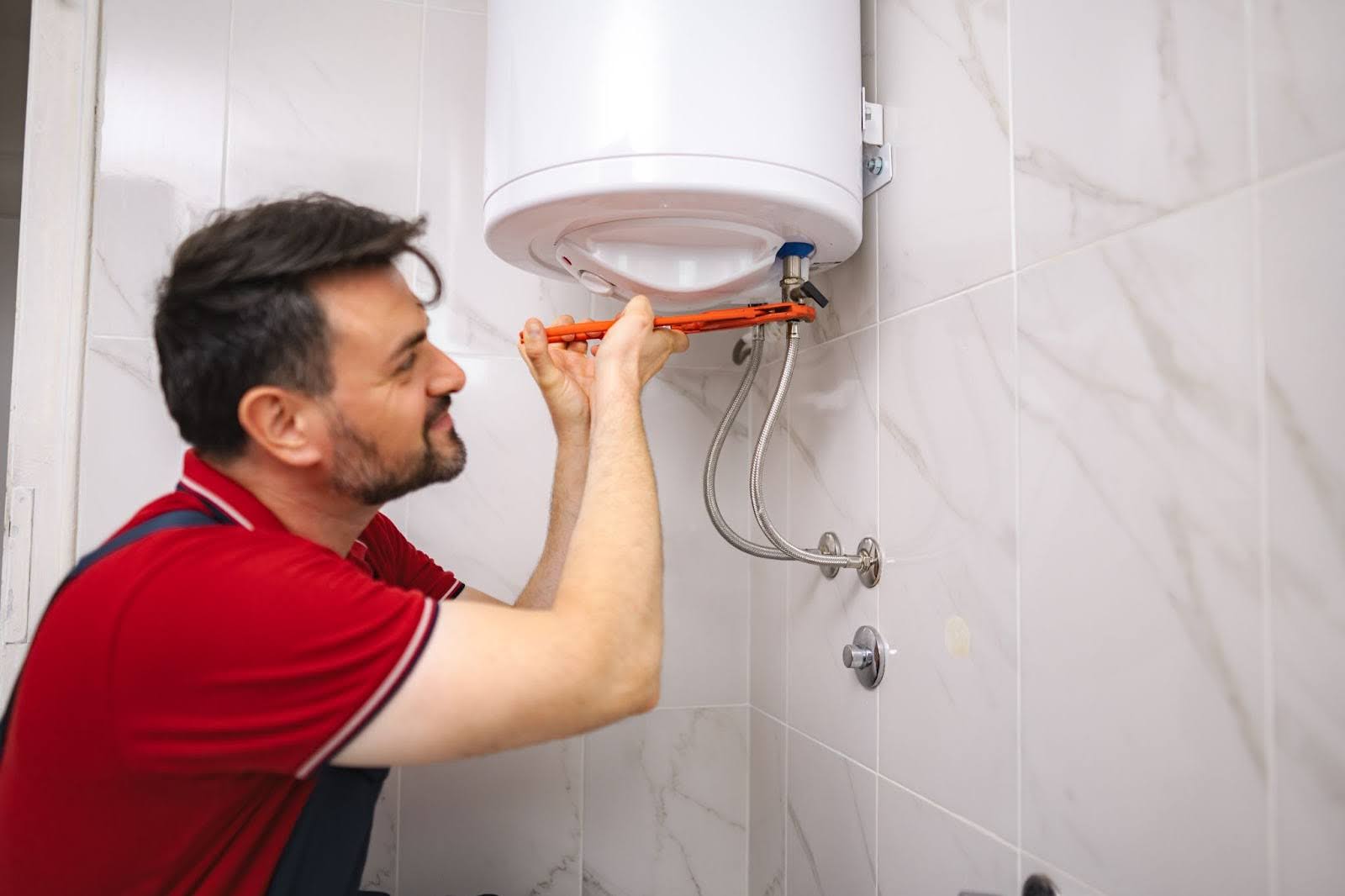 A plumber repairing a bathroom water heater unit.