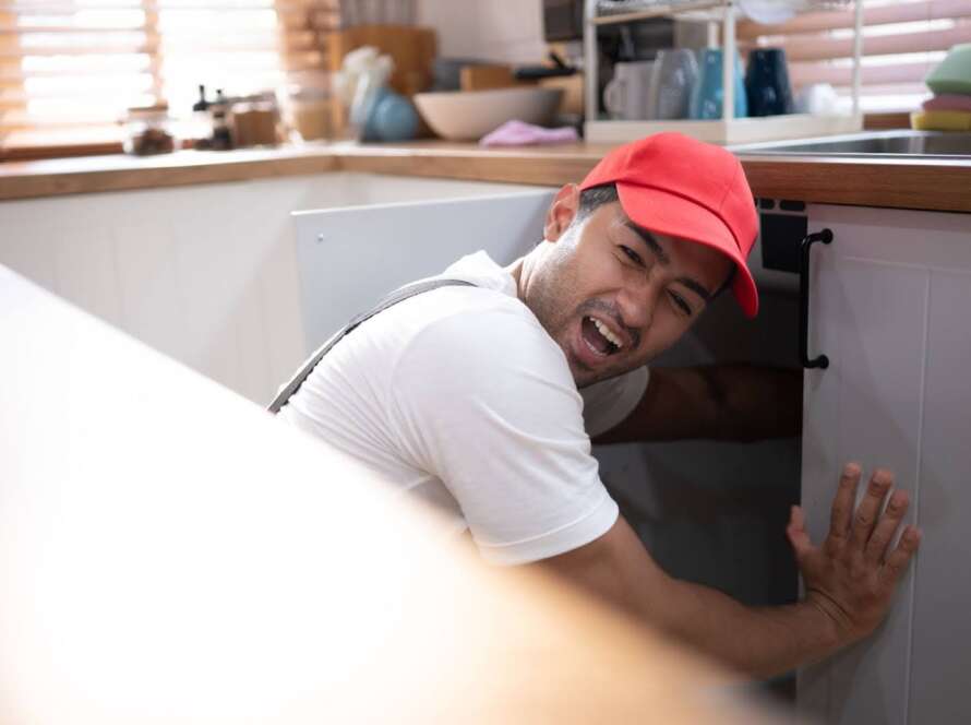 An experienced local plumber restoring proper water flow to a kitchen sink.