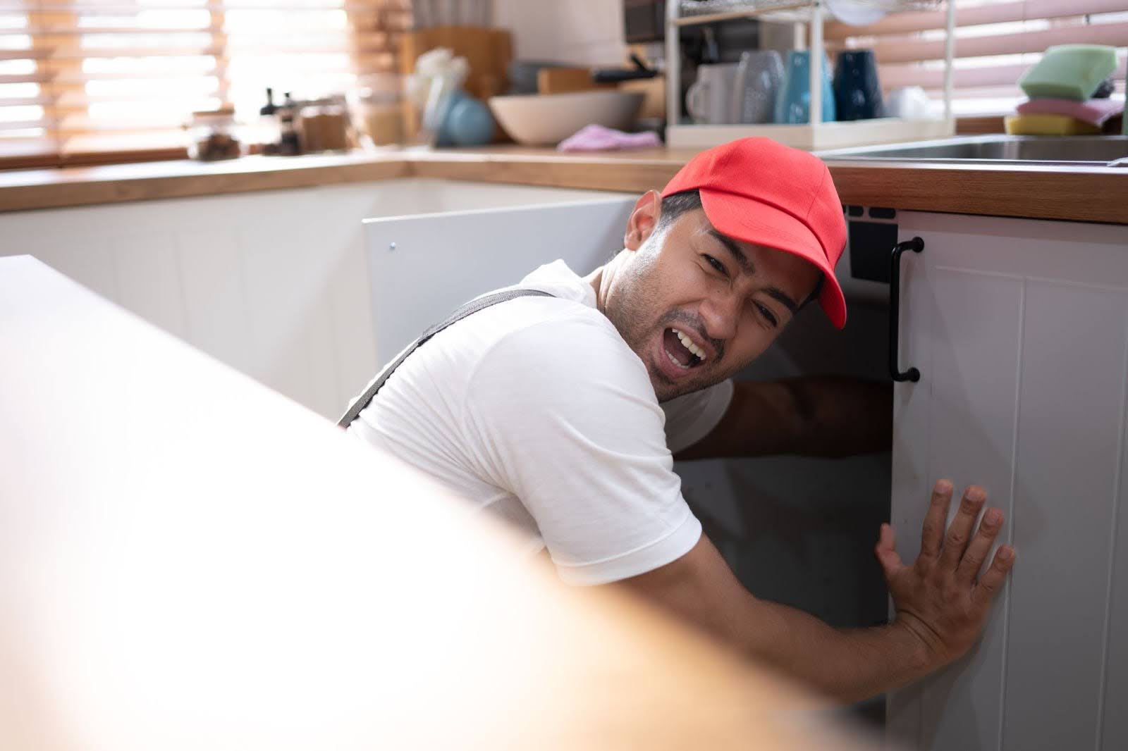 An experienced local plumber restoring proper water flow to a kitchen sink.