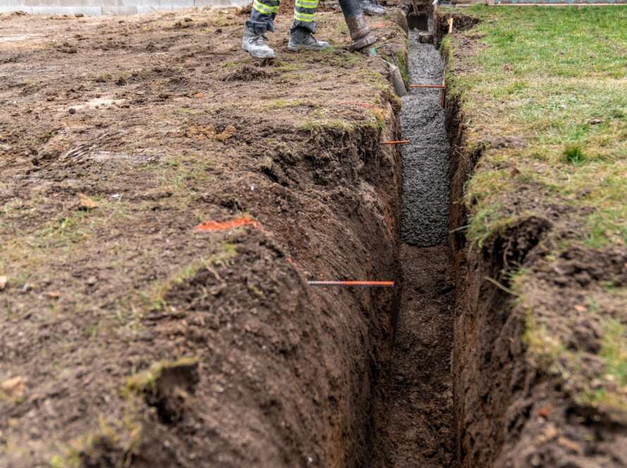 A trench is dug and cemented for the purposes of burying a sewer line.