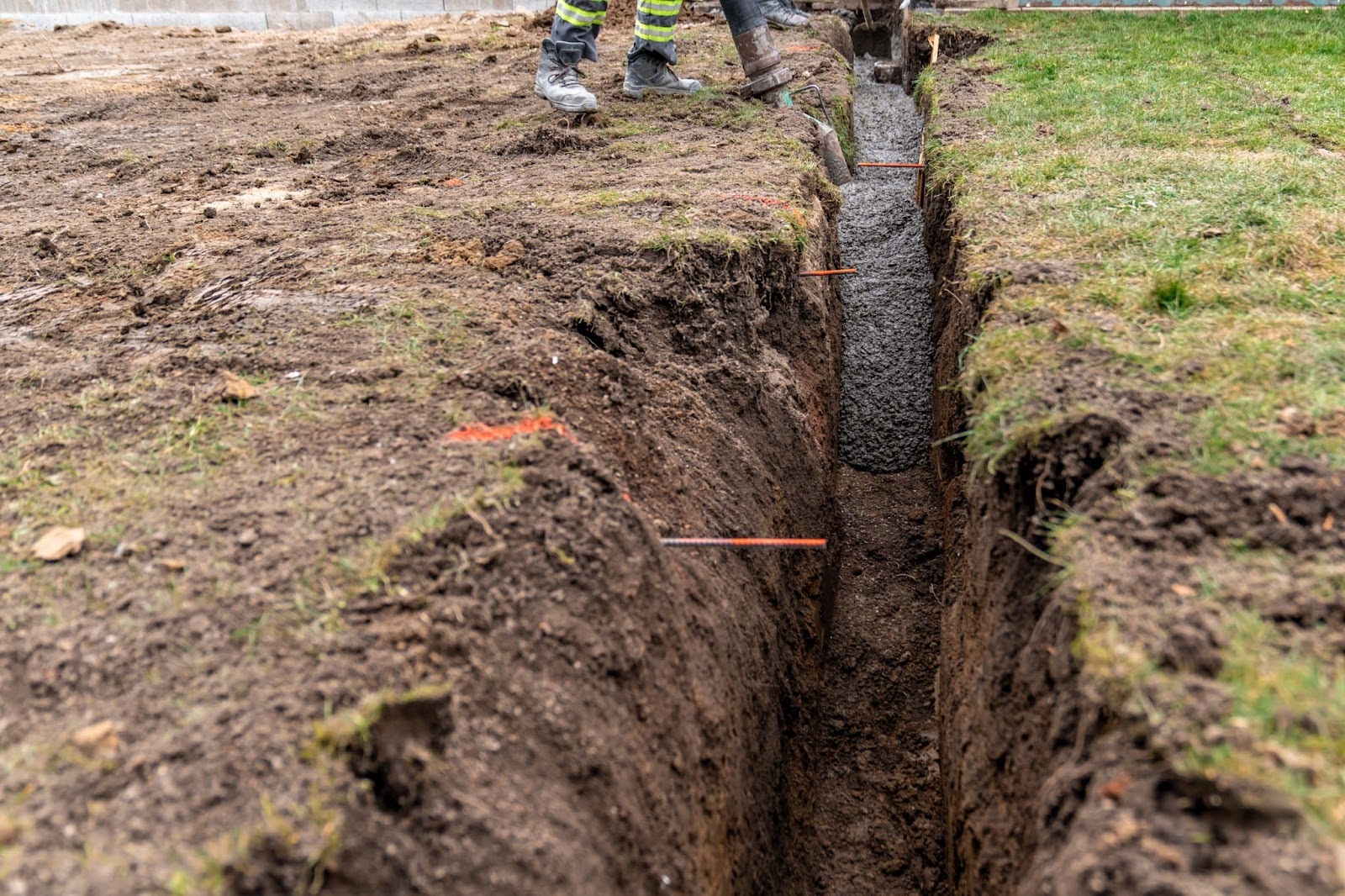 A trench is dug and cemented for the purposes of burying a sewer line.