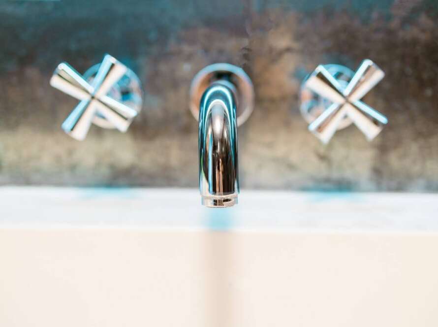 A chrome sink mounted into the wall with no leaks.